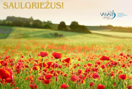 Sarkanu magoņu lauks zem saulainām debesīm, ar uzrakstu PRIECĪGUS VASARAS SAULGRIEŽUS!
