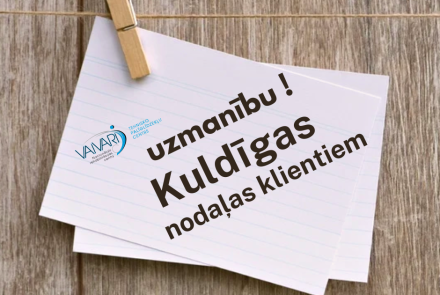 Pie virtenes piestiprinātā piezīmē rakstīts: UZMANĪBU! Kuldīgas nodaļas klientiem ar VANAPI logotipu uz koka fona.