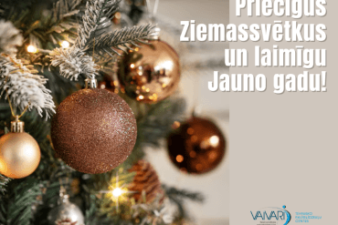 Rotāta Ziemassvētku eglīte ar zelta un bronzas rotājumiem. Labajā pusē ir teksts latviešu valodā: Priecīgus Ziemassvētkus un laimīgu Jauno gadu!, kas angļu valodā nozīmē Merry Christmas and Happy New Year!.